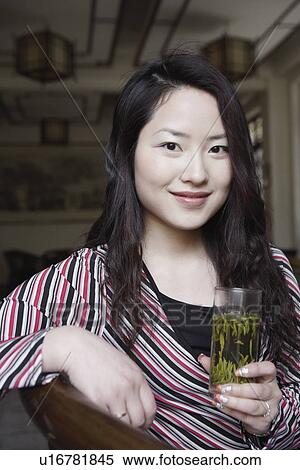 Stock Photography - Portrait of a young woman holding a glass. Fotosearch
