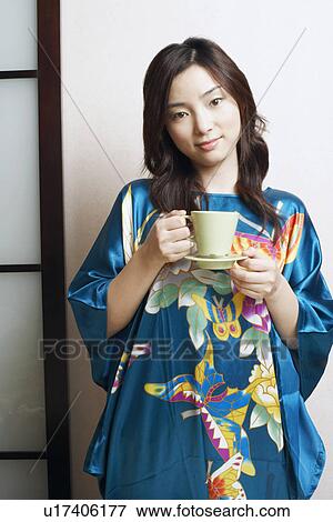 Stock Photo - Portrait of a young woman holding a tea cup. Fotosearch