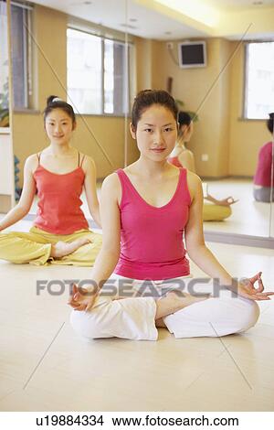 Portrait of a young woman sitting in the lotus position View Large Photo Image Picture - Portrait of a young woman sitting in the lotus position. Fotosearch