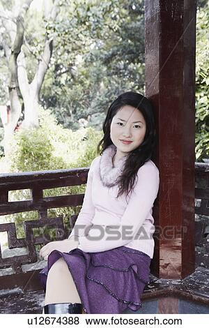 Portrait of a young woman sitting View Large Photo Image Stock Photo - Portrait of a young woman sitting. Fotosearch