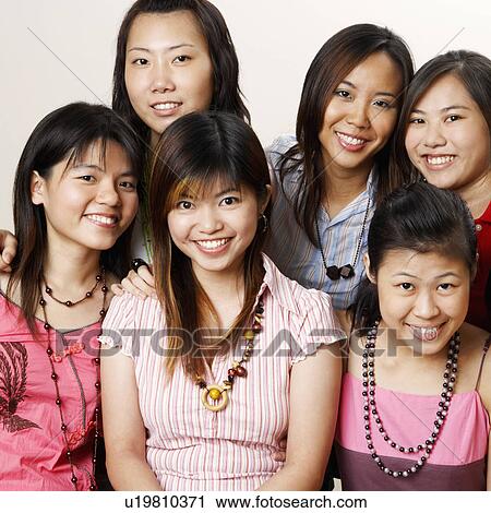 Stock Image - Portrait of four young women hugging each other and posing. Fotosearch