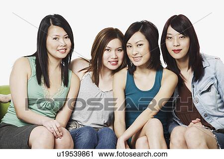 Portrait of four young women sitting on a couch smiling View Large Photo Image Stock Image - Portrait of four young women sitting on a couch smiling. Fotosearch