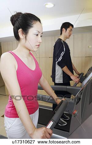 Side profile of a young woman and a young man exercising in a gym View Large Photo Image Stock Photo - Side profile of a young woman and a young man exercising in a gym. Fotosearch
