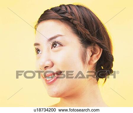 Stock Image - Portrait of a Young Adult Woman With her Hair Styled, Smiling and Looking Sideways, Side View. Fotosearch
