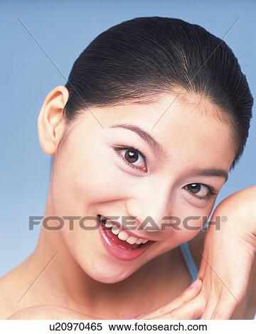 Closed Up Image of a Young Adult Woman In Front of a Blue Wall, Posing, Smiling, Looking at Camera View Large Photo Image Stock Photography - Closed Up Image of a Young Adult Woman In Front of a Blue Wall, Posing, Smiling, Looking at Camera. Fotosearch