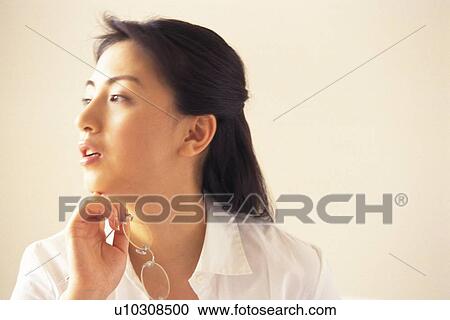 Stock Image - Image of a Mid Adult Woman, Holding her Glasses Looking Sideways, Side View, Copy Space. Fotosearch