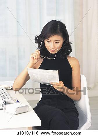 Image of a Mid Adult Woman Reading a Worksheet at her Desk, High Angle View View Large Photo Image Stock Photograph - Image of a Mid Adult Woman Reading a Worksheet at her Desk, High Angle View. Fotosearch