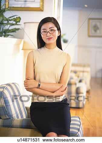 Image of a Mid Adult Woman Wearing Glasses, Sitting in a Living Room, Looking at Camera, Smiling, Front View, Differential Focus View Large Photo Image Stock Image - Image of a Mid Adult Woman Wearing Glasses, Sitting in a Living Room, Looking at Camera, Smiling, Front View, Differential Focus. Fotosearch