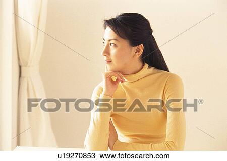 Stock Image - Image of a Young Adult Woman Dressed in Yellow, Looking Sideways, Side View. Fotosearch