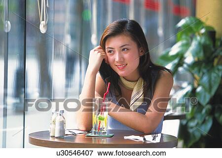 Image of a Young Adult Woman Having a Drink in a Café, Looking Sideways, Smiling, Front View View Large Photo Image Stock Photo - Image of a Young Adult Woman Having a Drink in a Café, Looking Sideways, Smiling, Front View. Fotosearch