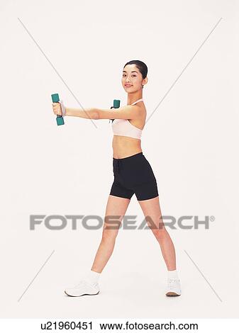 Image of a Young Adult Woman Posing and Lifting Some Weights, Smiling, Looking at Camera, Side View View Large Photo Image Stock Image - Image of a Young Adult Woman Posing and Lifting Some Weights, Smiling, Looking at Camera, Side View. Fotosearch