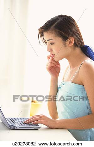 Image of a Young Adult Woman Working at her Computer, Side View View Large Photo Image Stock Image - Image of a Young Adult Woman Working at her Computer, Side View. Fotosearch