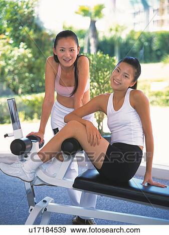 Stock Photo - Image of Two Young Adult Women About to do Some Exercises, Smiling, Front View, Side View. Fotosearch