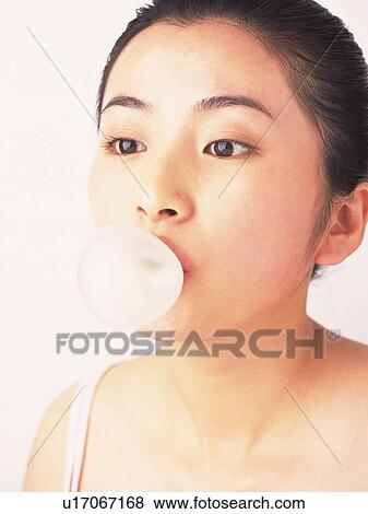 Stock Photo - Japanese woman blowing bubblegum. Fotosearch