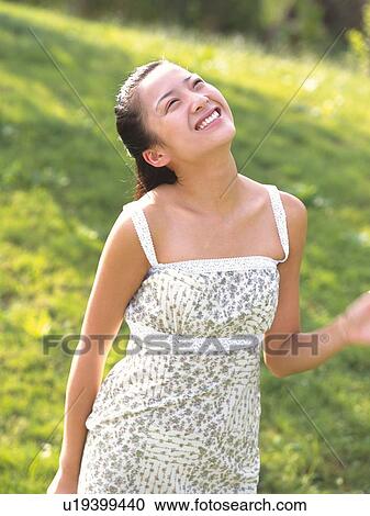 Japanese woman Looking up in green field View Large Photo Image Stock Image - Japanese woman Looking up in green field. Fotosearch