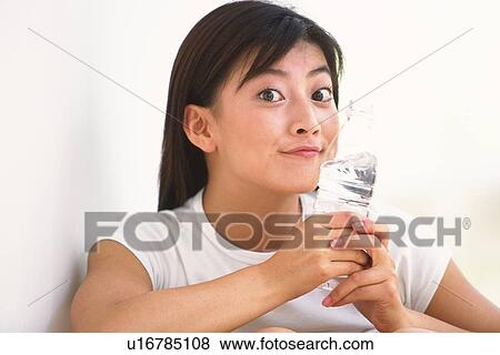 Japanese woman smiling and holding a plastic bottle View Large Photo Image Stock Photo - Japanese woman smiling and holding a plastic bottle. Fotosearch