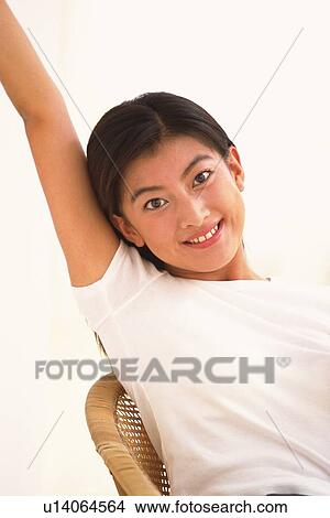 Picture - Japanese woman smiling and lifting her arm up. Fotosearch