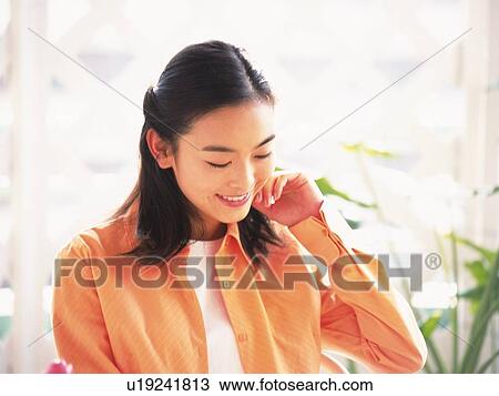 Japanese woman smiling and looking down View Large Photo Image Stock Image - Japanese woman smiling and looking down. Fotosearch
