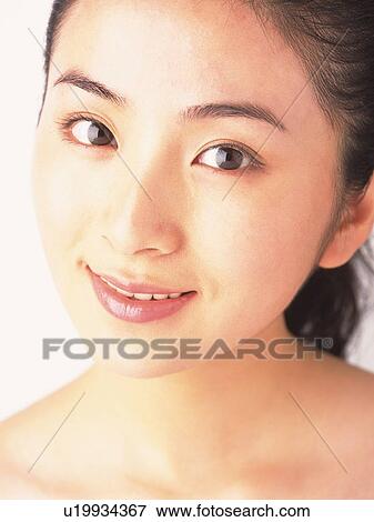Stock Photo - Japanese woman smiling to camera, close up. Fotosearch