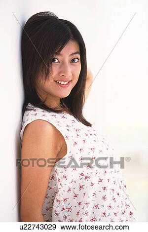 Portrait of Japanese woman smiling and leaning on wall View Large Photo Image Stock Photo - Portrait of Japanese woman smiling and leaning on wall. Fotosearch