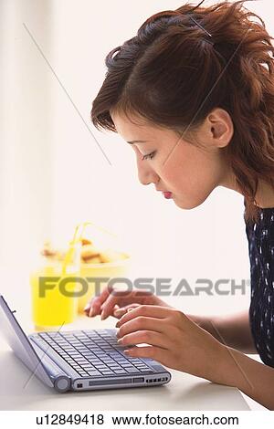 Profile of woman using a laptop View Large Photo Image Stock Photo - Profile of woman using a laptop. Fotosearch