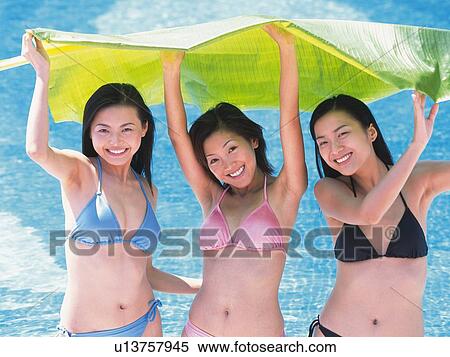 Three women lifting large leaf over heads in the pool View Large Photo Image Stock Photography - Three women lifting large leaf over heads in the pool. Fotosearch