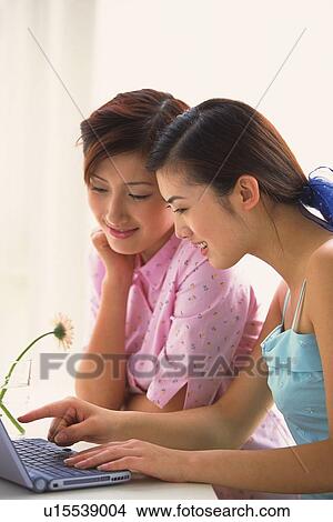 Picture - Two women using laptop. Fotosearch