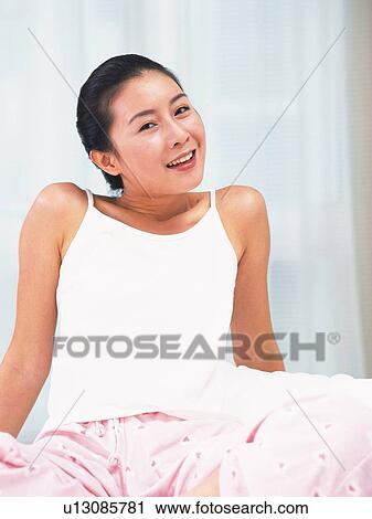 Stock Image - Woman smiling and looking at camera. Fotosearch