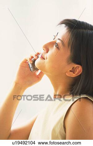 Woman using mobile phone, looking up View Large Photo Image Picture - Woman using mobile phone, looking up. Fotosearch