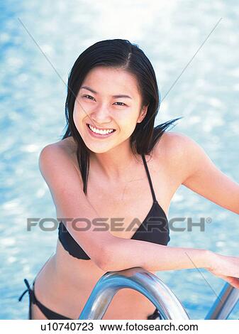 Woman wearing bikini, standing on ladder of the pool View Large Photo Image Stock Image - Woman wearing bikini, standing on ladder of the pool . Fotosearch