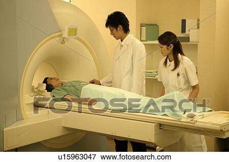 Doctor preparing patient for a MRI scan View Large Photo Image Stock Photo - Doctor preparing patient for a MRI scan. Fotosearch