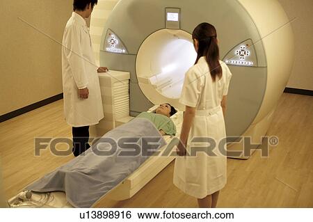 Doctor preparing patient for a MRI scan View Large Photo Image Stock Photograph - Doctor preparing patient for a MRI scan. Fotosearch