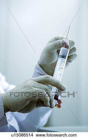 Human hand holding syringe View Large Photo Image Picture - Human hand holding syringe . Fotosearch
