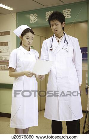 Stock Image - Nurse listening to doctor . Fotosearch