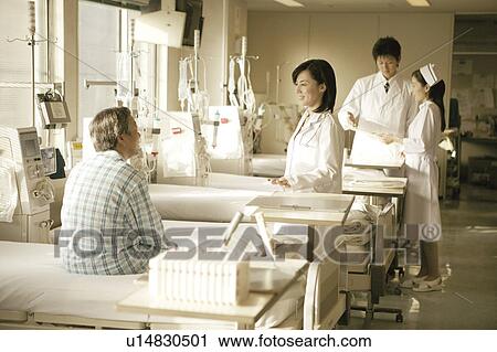 Stock Image - Nurse talking with patient. Fotosearch