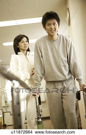 Picture - Young nurse assisting beside man using orthopedic walker . Fotosearch