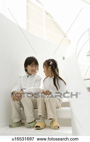 Photography of a boy and girl talking on the stairs, Low Angle View View Large Photo Image Stock Photo - Photography of a boy and girl talking on the stairs, Low Angle View. Fotosearch