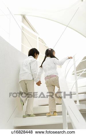 Photography of a boy and girl walking up the stairs, Low Angle View View Large Photo Image Stock Photo - Photography of a boy and girl walking up the stairs, Low Angle View. Fotosearch