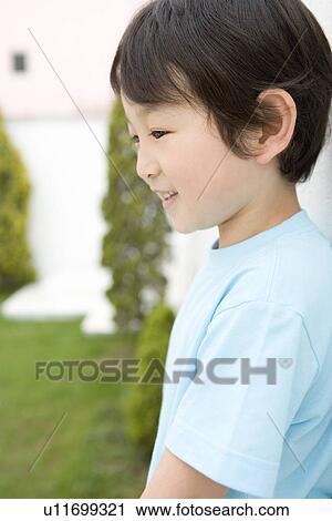 Stock Image - Photography of a boy in the garden, Side View. Fotosearch