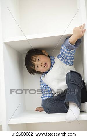 Photography of a boy playing in a shelf, Low Angle View View Large Photo Image Stock Image - Photography of a boy playing in a shelf, Low Angle View. Fotosearch
