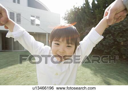 Stock Photograph - Photography of a boy smiling at camera with holded hands, High Angle View. Fotosearch