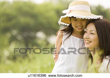 Stock Photograph - Photography of a daughter and mother in the field, Differential Focus. Fotosearch