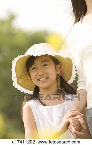 Stock Image - Photography of a daughter holding mother's hand, Differential Focus. Fotosearch