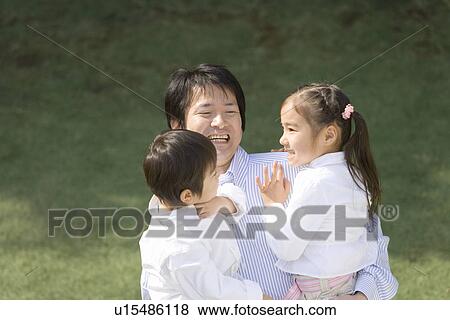 Stock Photo - Photography of a father and children playing, High Angle View. Fotosearch