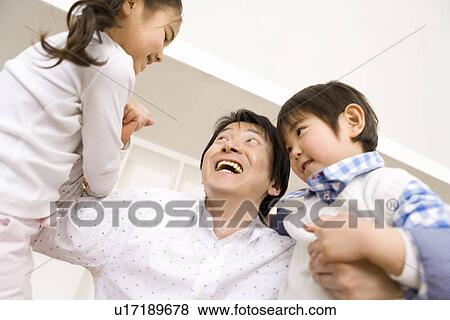 Stock Photo - Photography of a father and children playing, Low Angle View. Fotosearch