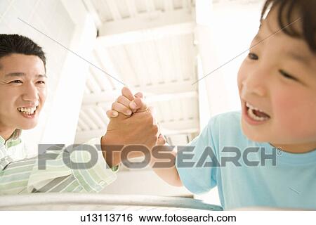 Stock Photograph - Photography of a father and son playing, Low Angle View. Fotosearch