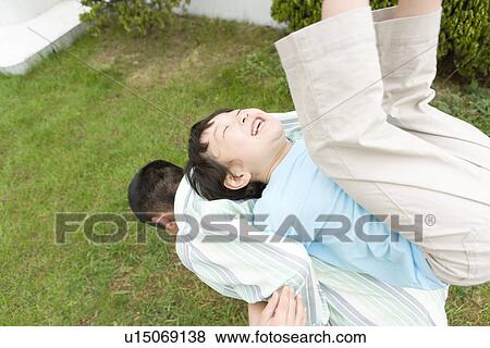 Stock Photo - Photography of a father lifting son up on the back, High Angle View. Fotosearch
