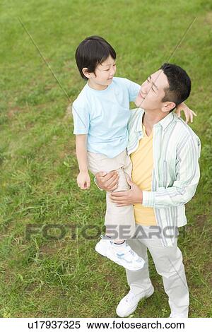 Stock Photography - Photography of a father lifting son up, High Angle View. Fotosearch