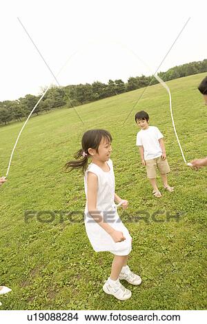 Photography of a girl and a boy playing with jumping rope, High Angle View View Large Photo Image Picture - Photography of a girl and a boy playing with jumping rope, High Angle View. Fotosearch