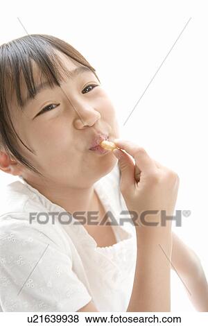 Stock Photo - Photography of a girl having sweets, High Angle View. Fotosearch